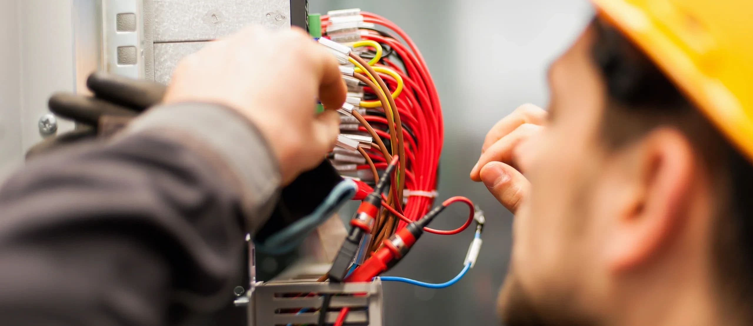 Electrician tracing and terminating wiring inside an electrical panel
